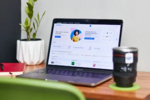 Laptop hiển thị trang hồ sơ Facebook cạnh chậu cây