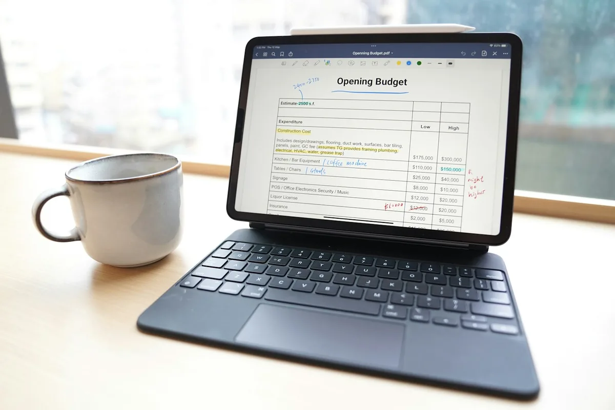 Laptop và sổ ghi chép đặt trên bàn làm việc