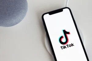 Điện thoại hiển thị logo TikTok trên đế sạc cạnh loa