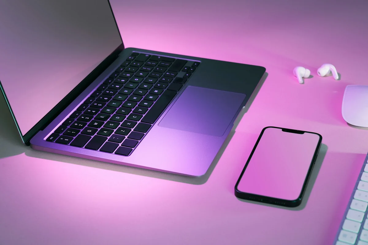 Laptop và điện thoại trên bàn làm việc màu tím