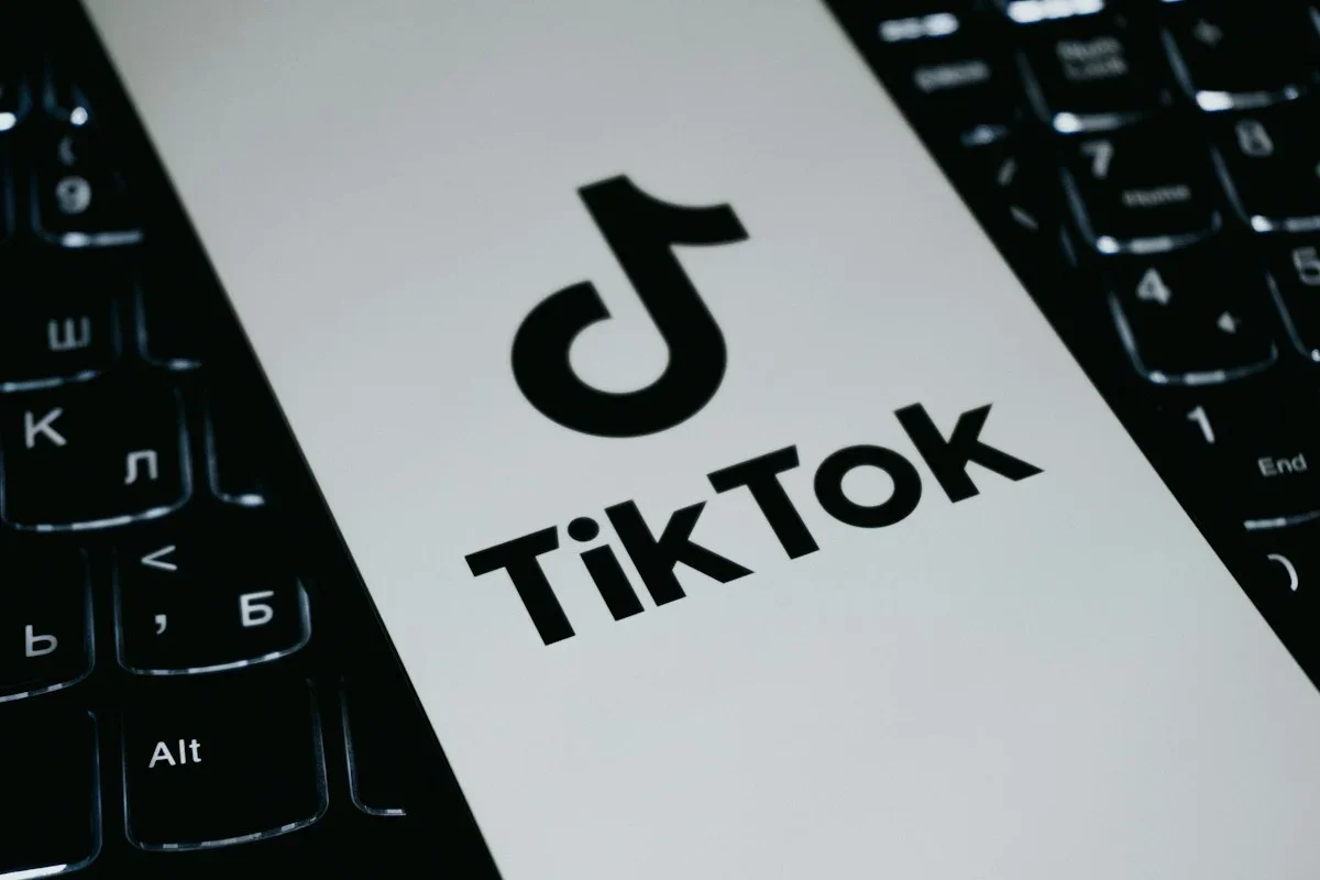 Điện thoại hiển thị TikTok trên nền bàn phím máy tính