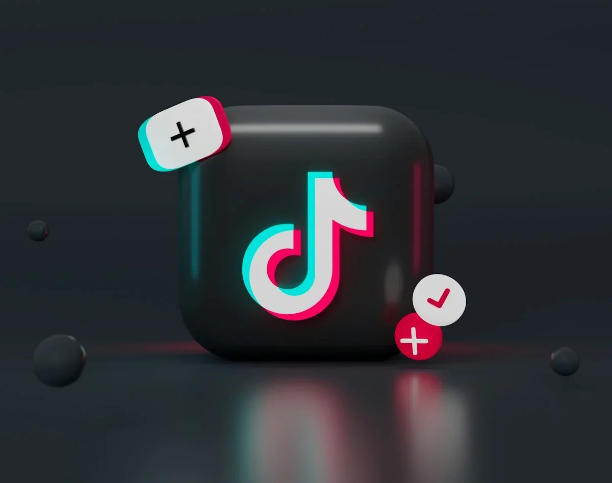 Biểu tượng TikTok cùng dấu cộng và dấu kiểm trên nền tối