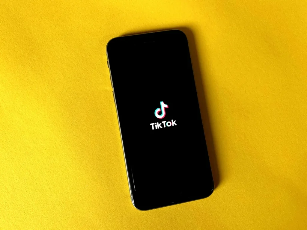 Điện thoại hiển thị logo TikTok trên nền vàng